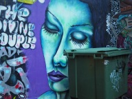 Woman's face mural with bin